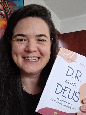 Autora com seu livro publicado pela Pluralidades